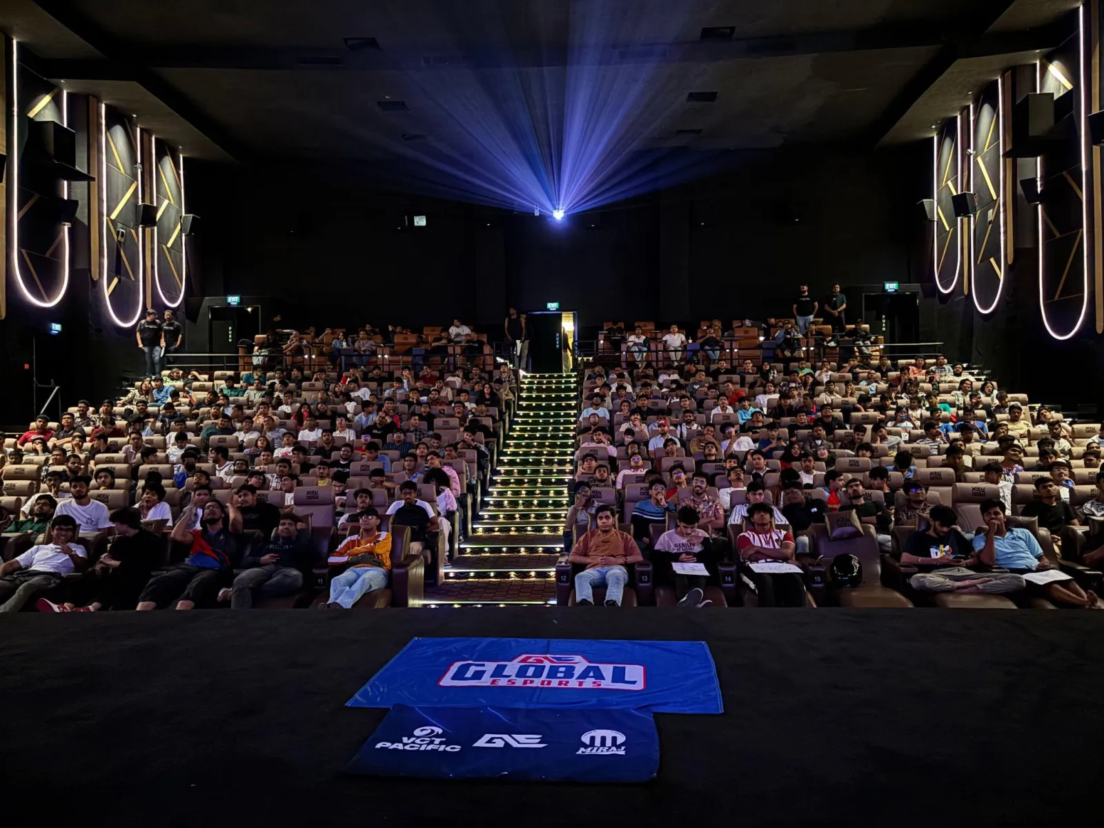 A full cinema hall with a GE flag laid out in front of the screen