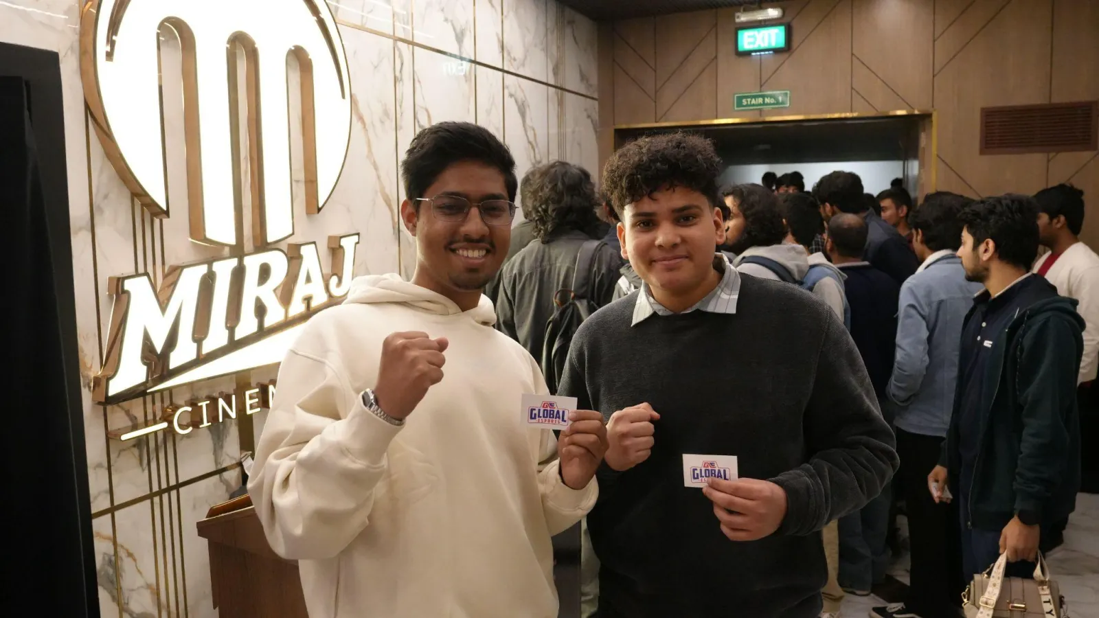 Two fans hold up their tickets at the Miraj Cinemas entrance